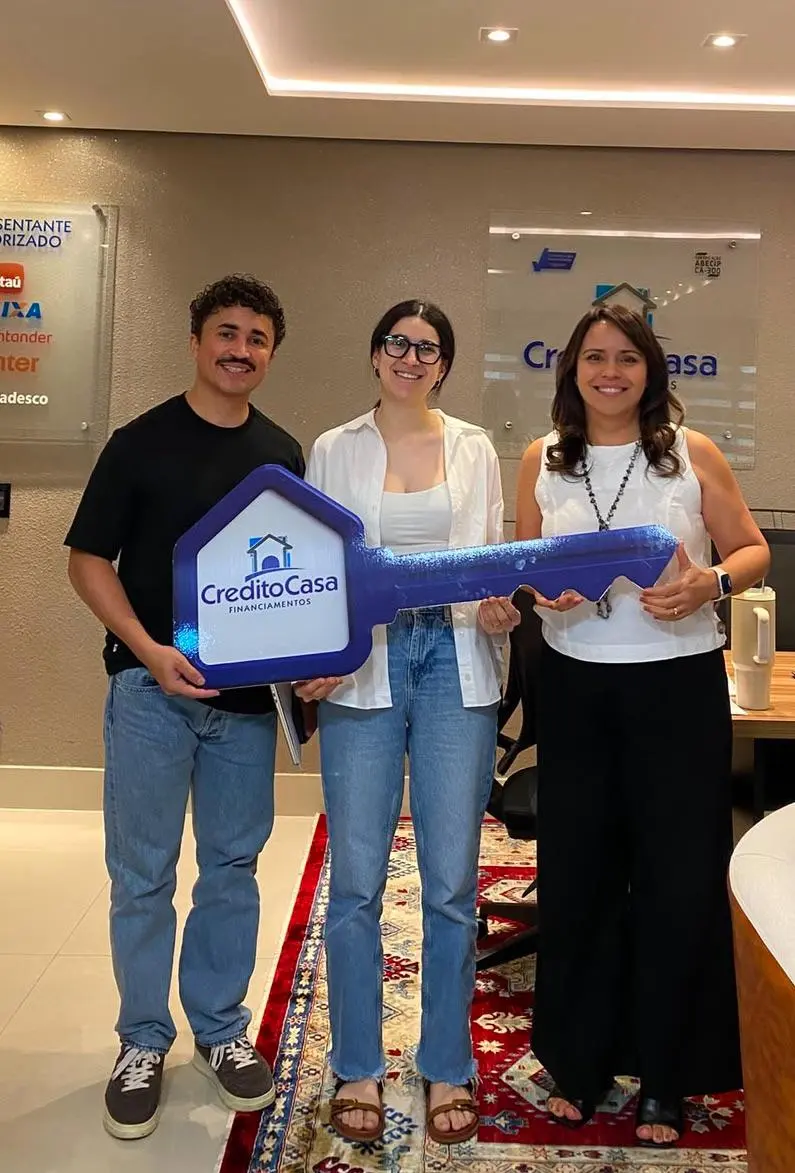 Casal celebrando o financiamento aprovado com a chave simbólica